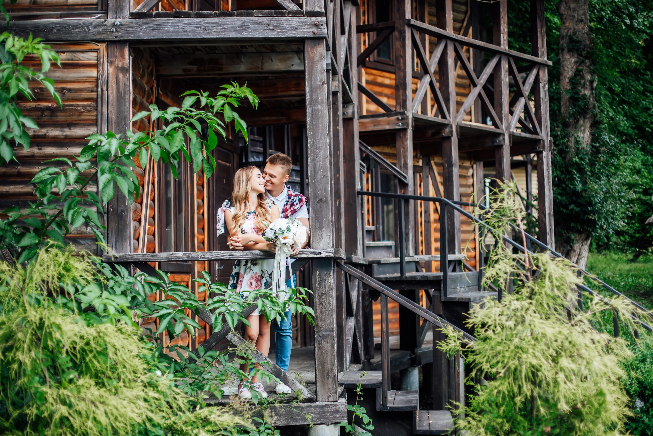 Resting together. Blonde girl and her strong man hugging and relaxing on fresh air in the mountains.